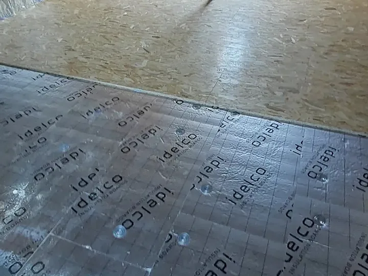 Plancher de combles recouvert d'une feuille isolante réfléchissante, panneaux OSB au fond