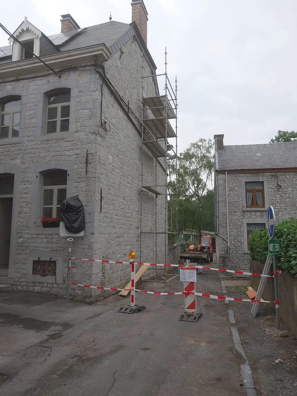 Maison en pierre avec échafaudage et ruban de chantier