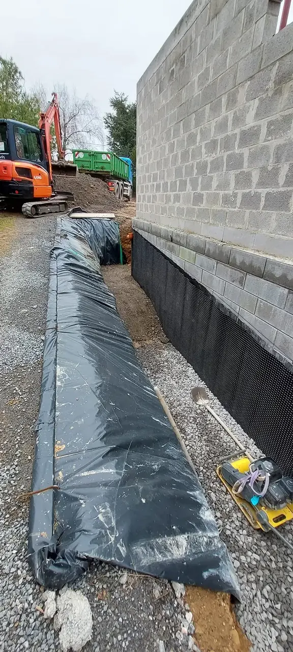 Mur de blocs avec soubassement bitumé et mini-pelle