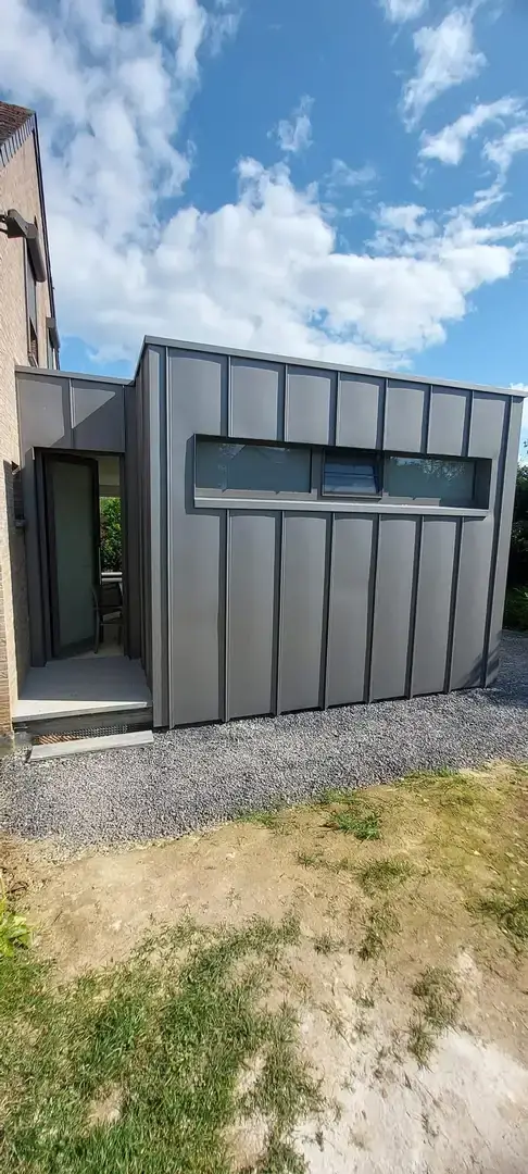 Annexe terminée avec bardage zinc et fenêtre en bandeau
