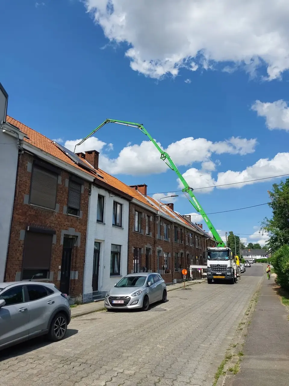 Camion-pompe à béton dans une rue de maisons mitoyennes