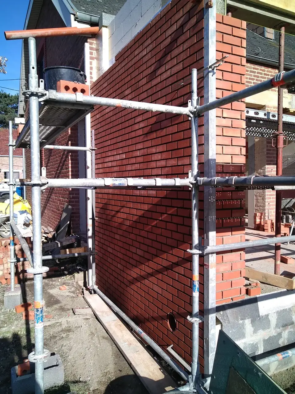 Nouveau mur de briques rouges avec échafaudage