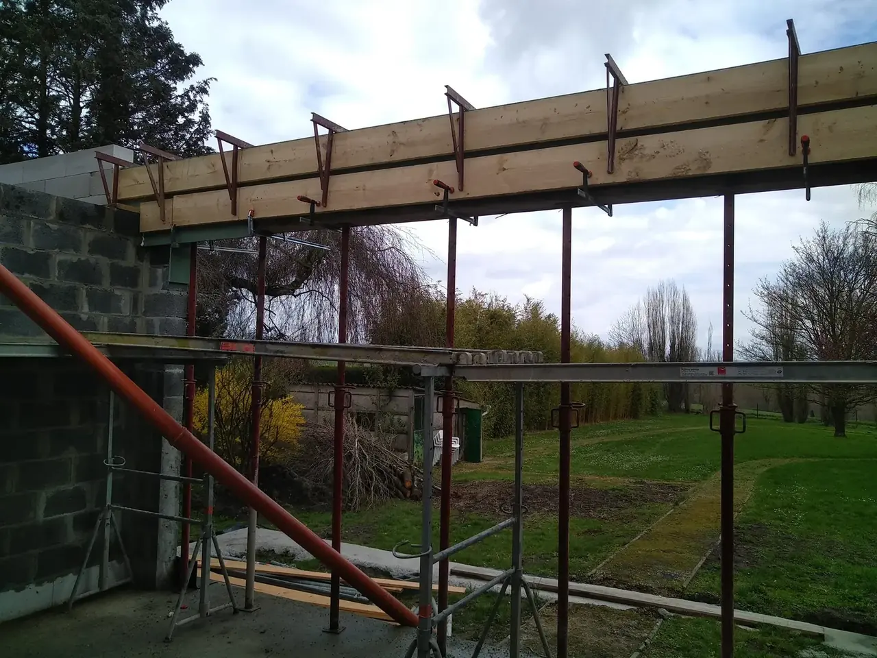 Poutres de la terrasse couverte et échafaudage vus de l'intérieur