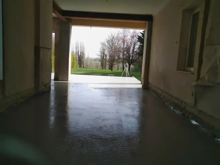 Sol de béton lissé dans une grande pièce ouverte sur le jardin