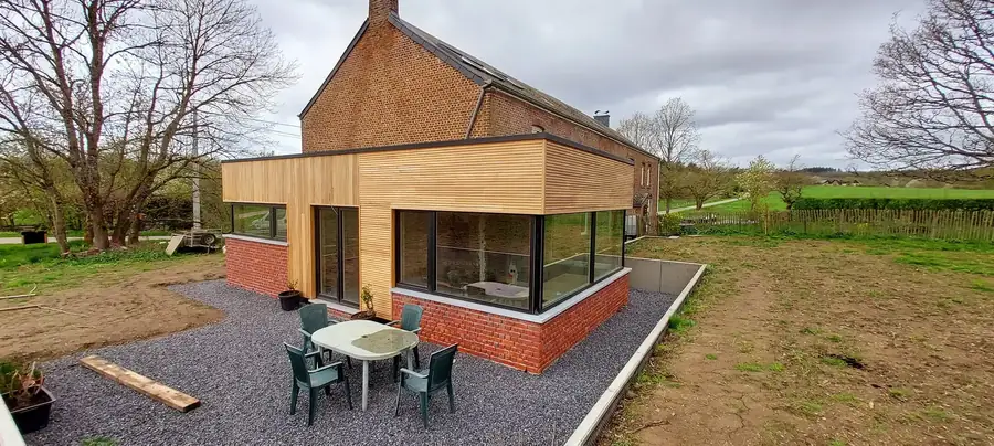 Annexe terminée avec bardage bois, baie vitrée et salon de jardin