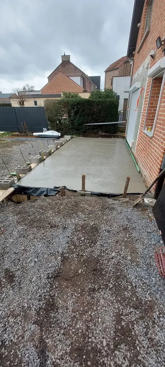 Dalle de béton coulée le long de la maison