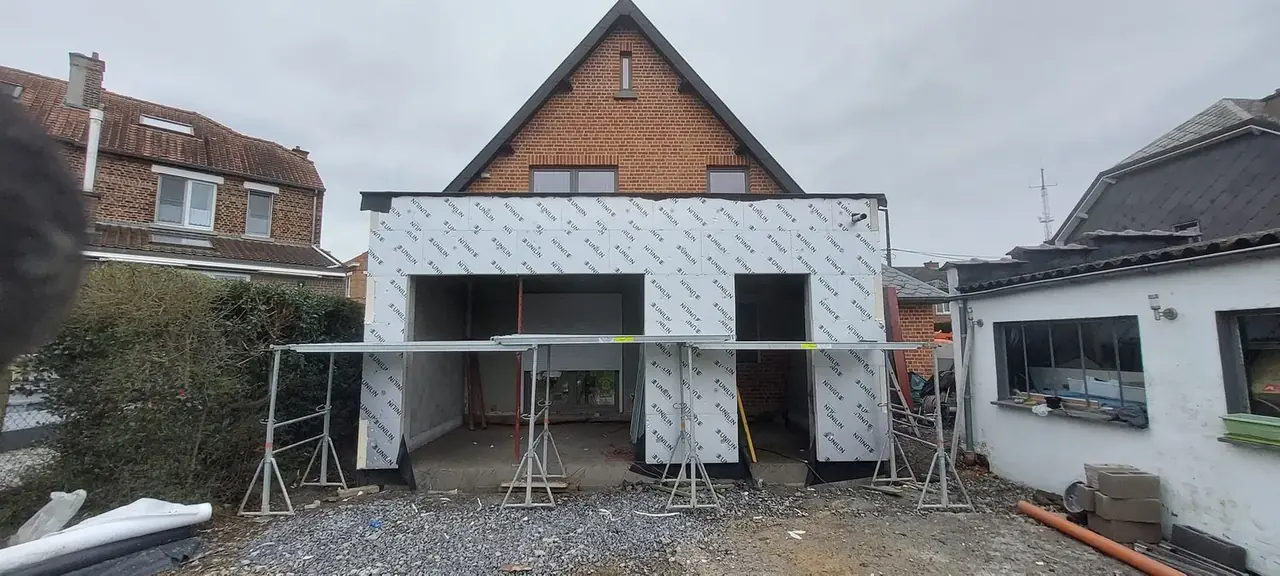 Annexe en blocs avec ossature devant la maison en briques