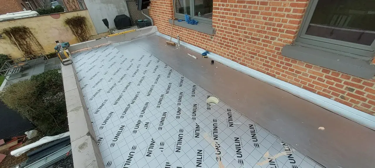 Isolant de toiture posé contre la façade en briques