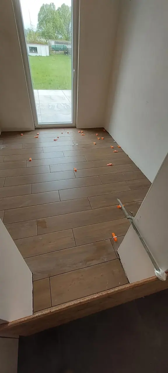 Sol carrelé effet bois devant une porte-fenêtre