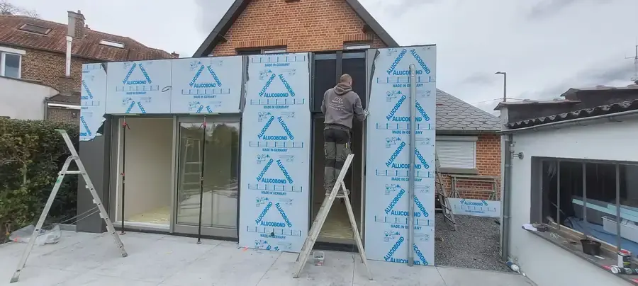 Annexe avec baie vitrée et isolant en cours de pose du bardage