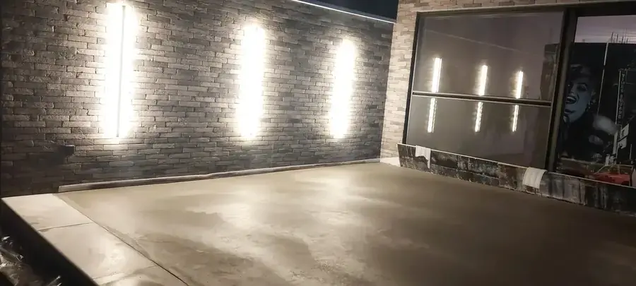 Terrasse en béton lissé le soir sous les spots de façade