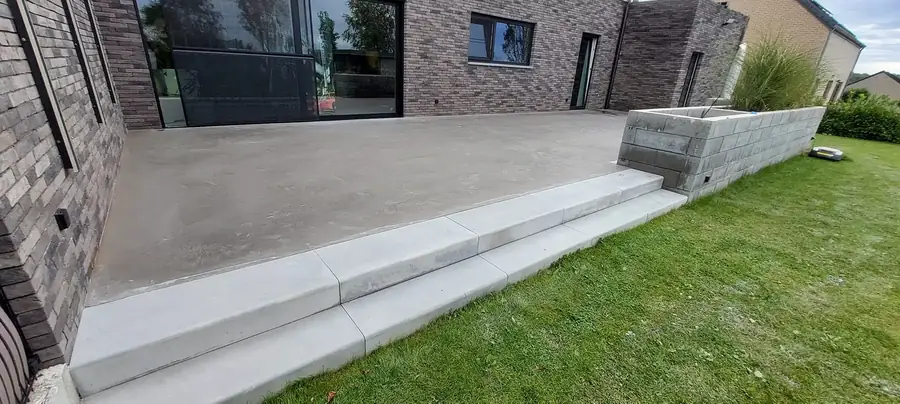Terrasse en béton lissé avec marche et pelouse