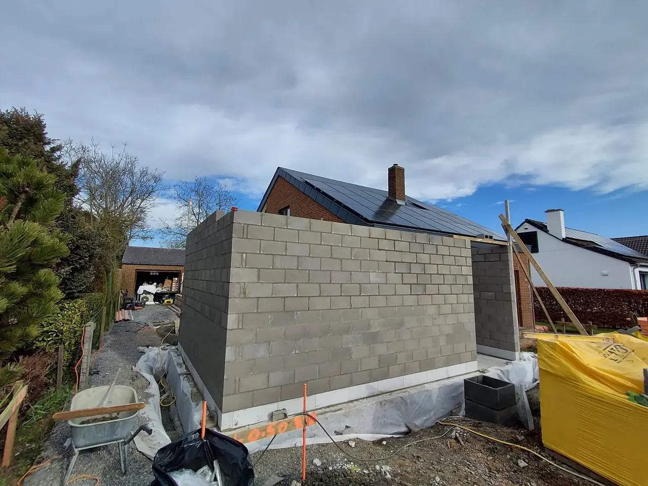 Murs en blocs de l'extension à côté d'un sac de chantier jaune