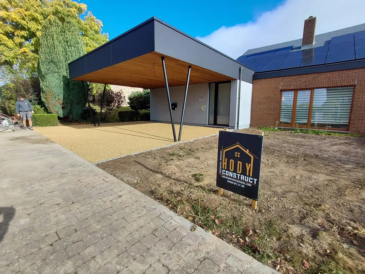 Carport terminé avec toit en bois et panneau de chantier