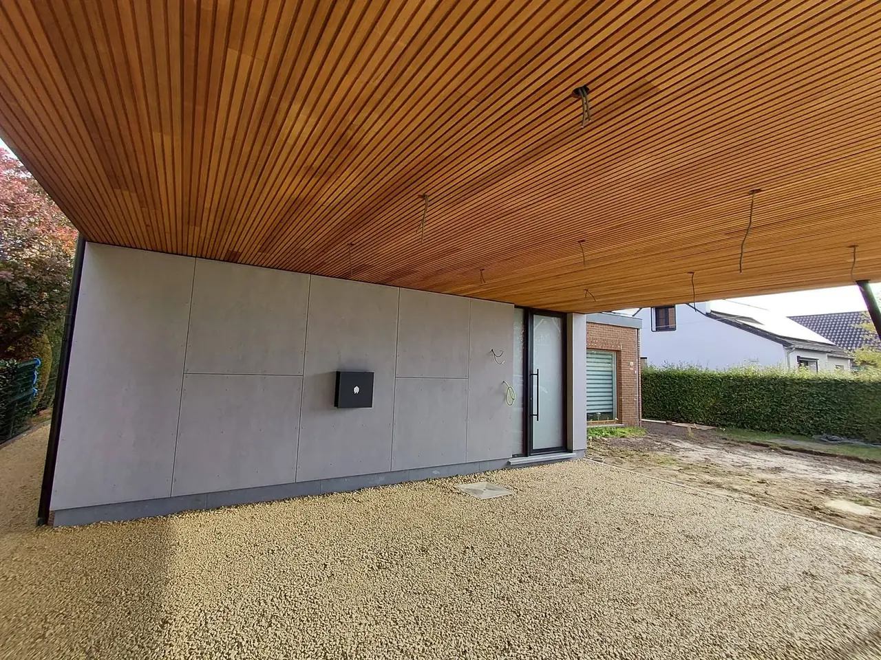 Sous-face en bois du carport et façade en panneaux gris