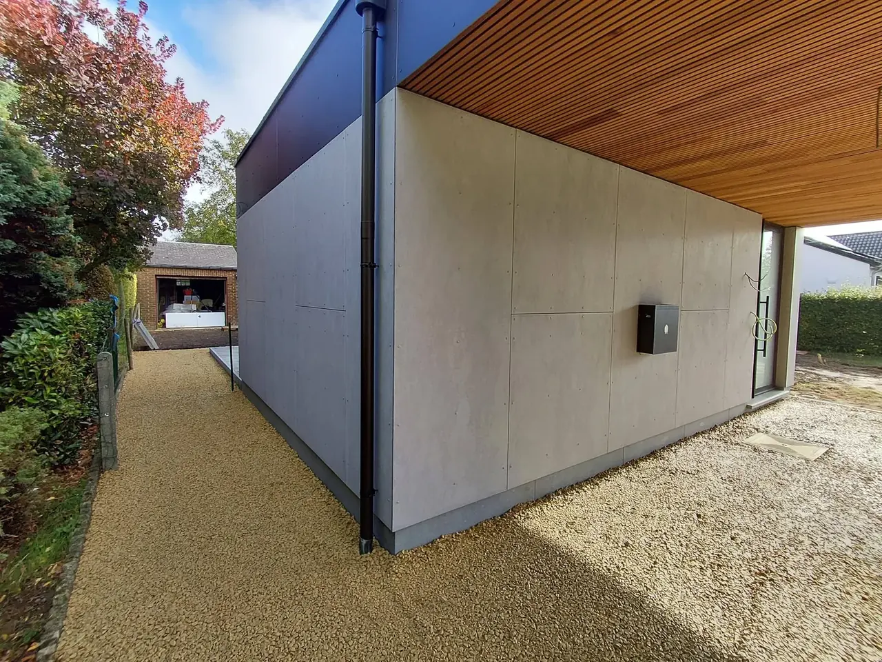 Extension avec façade grise et toit en bois, vue de côté