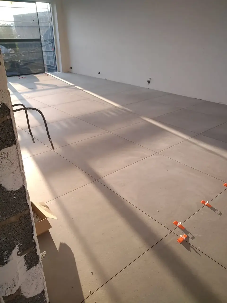 Pièce carrelée de grands carreaux avec lumière rasante