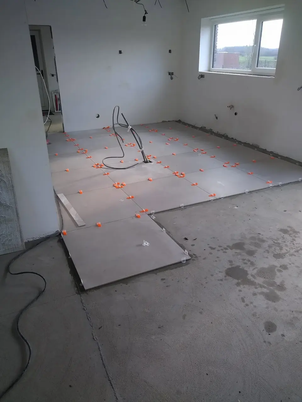 Carrelage en cours de pose dans la pièce de vie