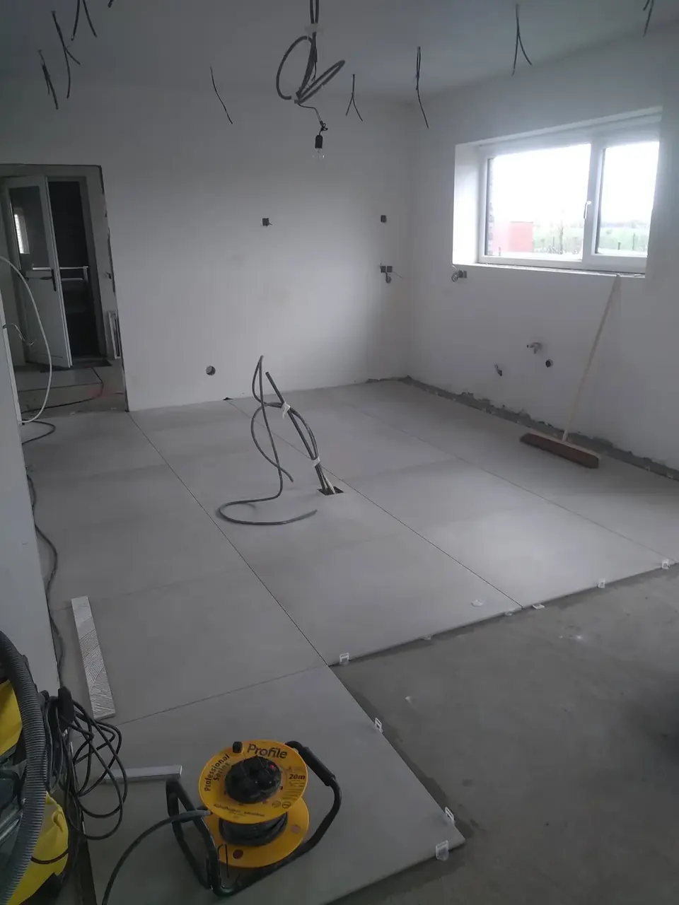 Pièce de vie en cours de carrelage avec fenêtre