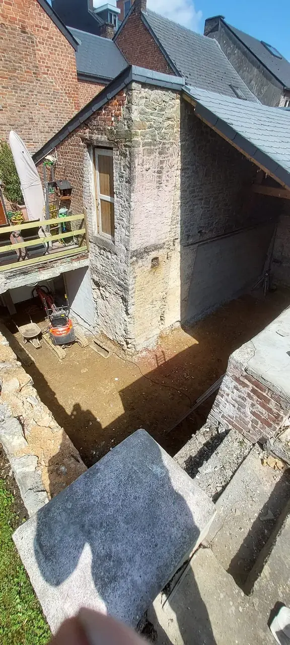 Excavation dans la cour avec murs anciens