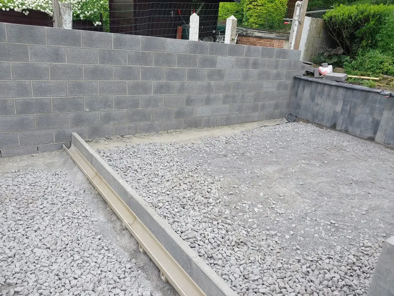 Murs de blocs gris et gravier dans la cour
