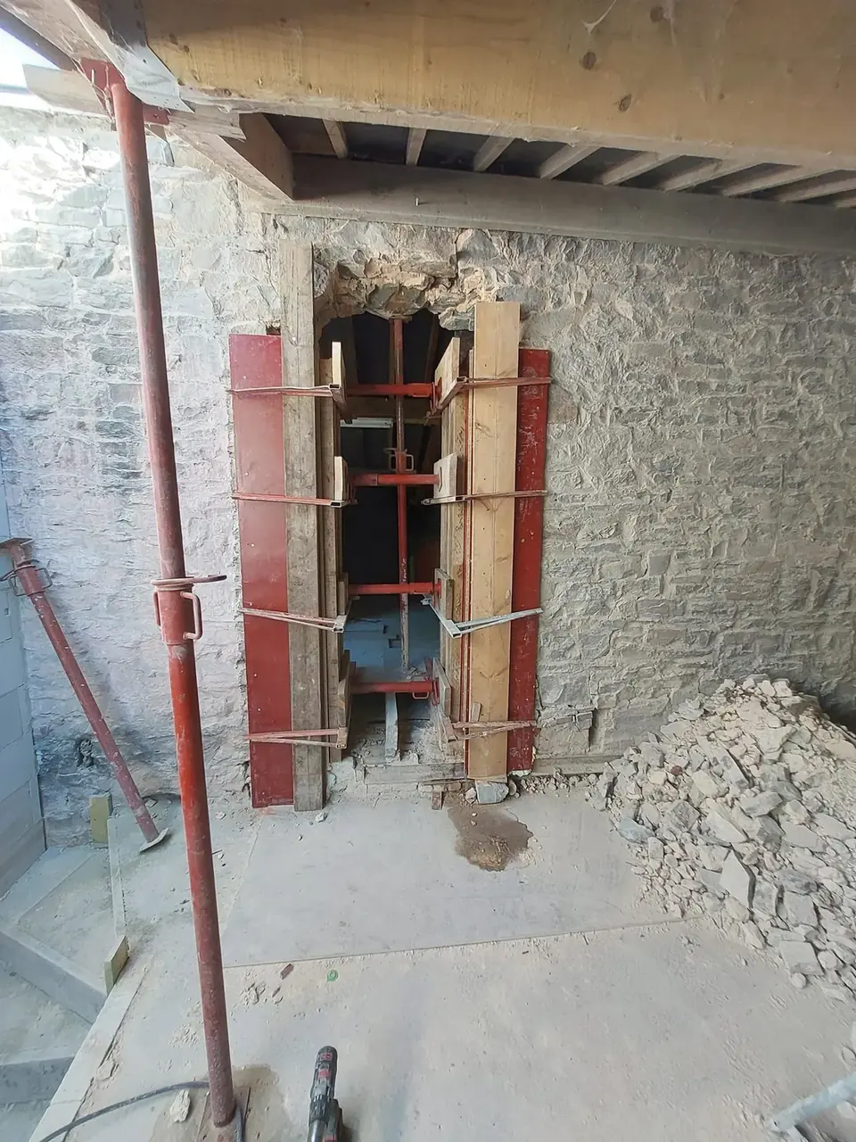 Étais et coffrage autour d'une ouverture dans un mur de pierre