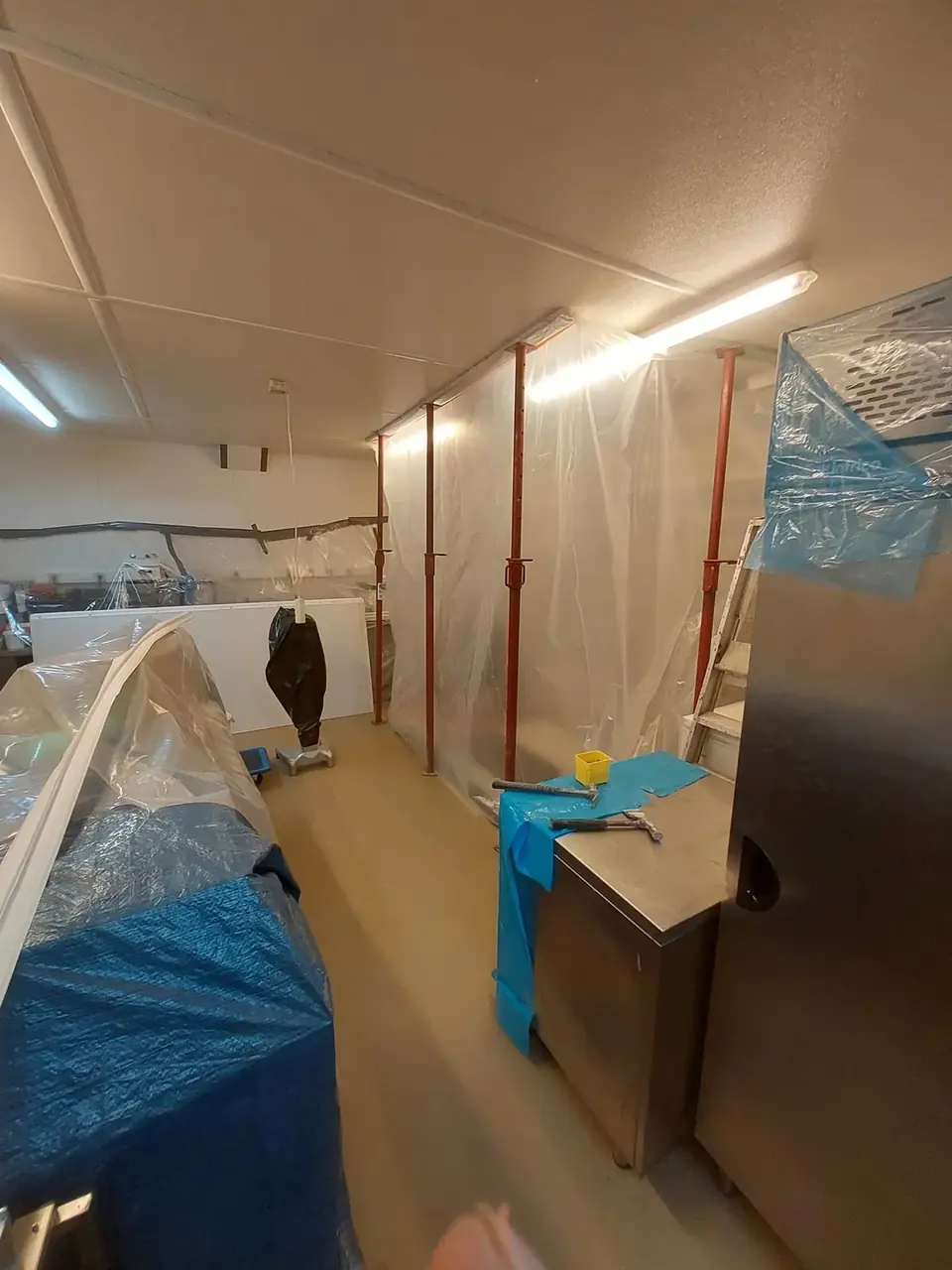Couloir protégé par des bâches, étais et plafond posé