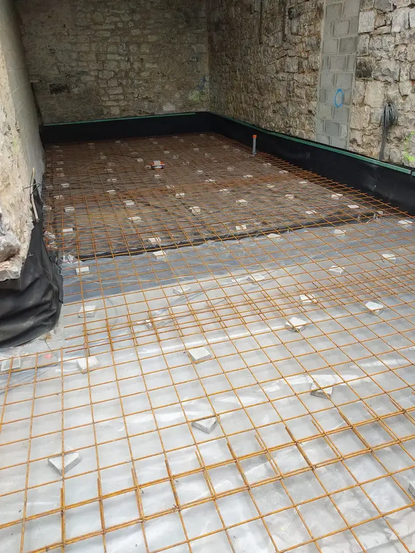 Armatures de dalle contre un mur en pierre