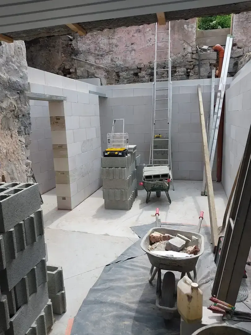 Murs en blocs avec échelle et matériel au centre d'une pièce