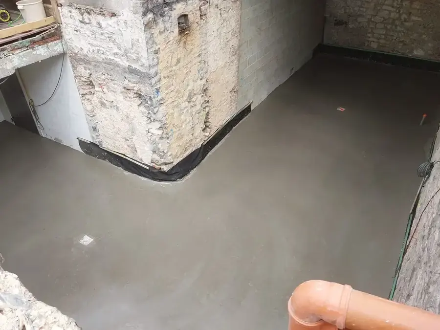 Dalle de béton brut dans un angle de bâtiment en pierre