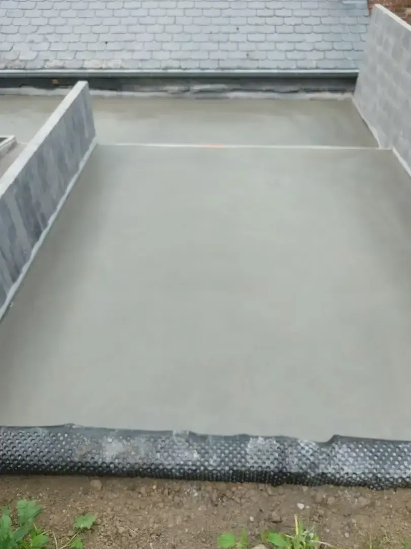 Dalle de béton lissée sur une terrasse longeant une toiture
