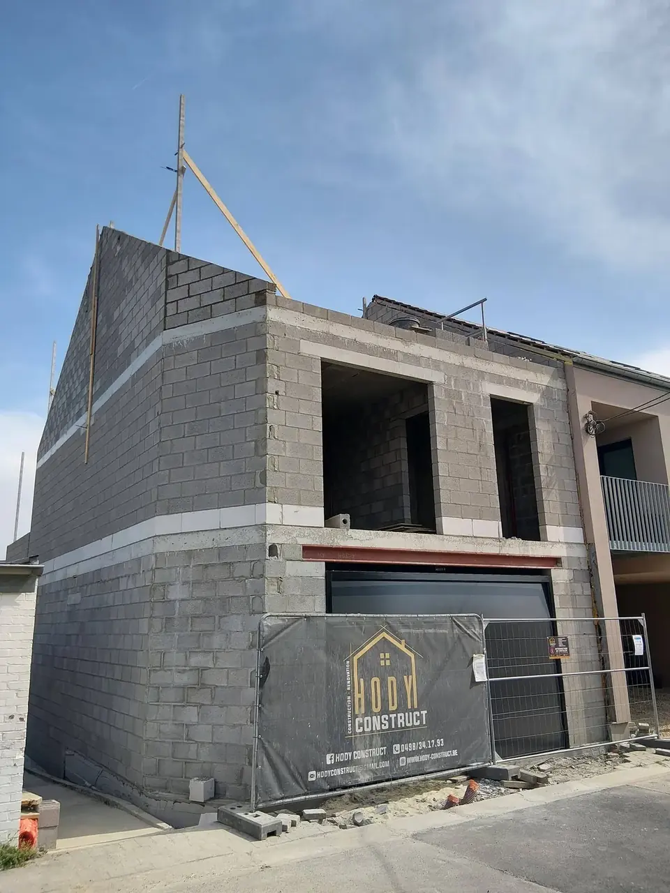 Bâtiment en blocs avec garage et bâche de chantier