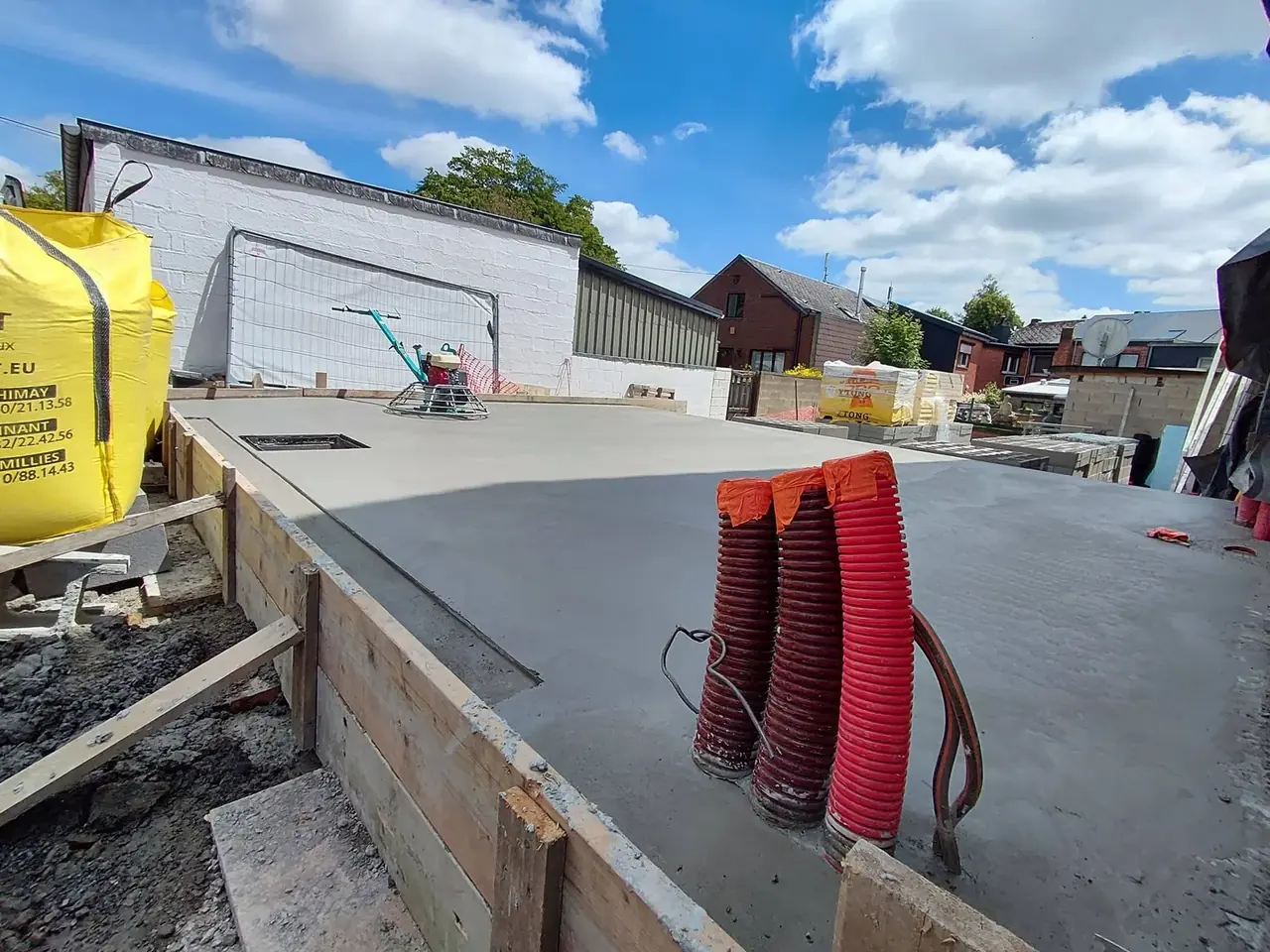 Dalle de béton lissée avec tuyaux rouges