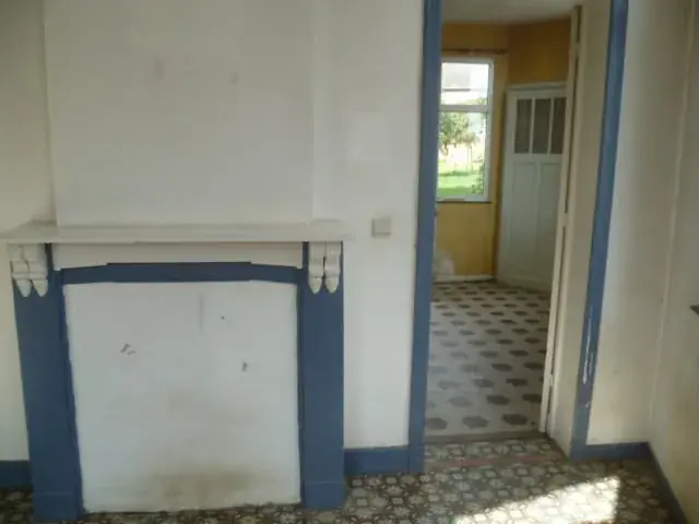 Cheminée peinte et passage vers la pièce voisine