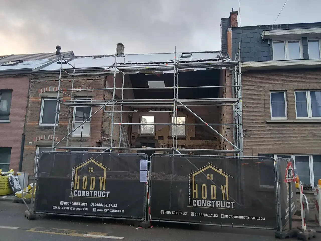 Façade de maison avec échafaudage et bâches de chantier