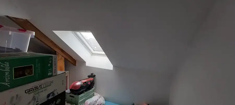 Chambre sous toiture avec fenêtre de toit
