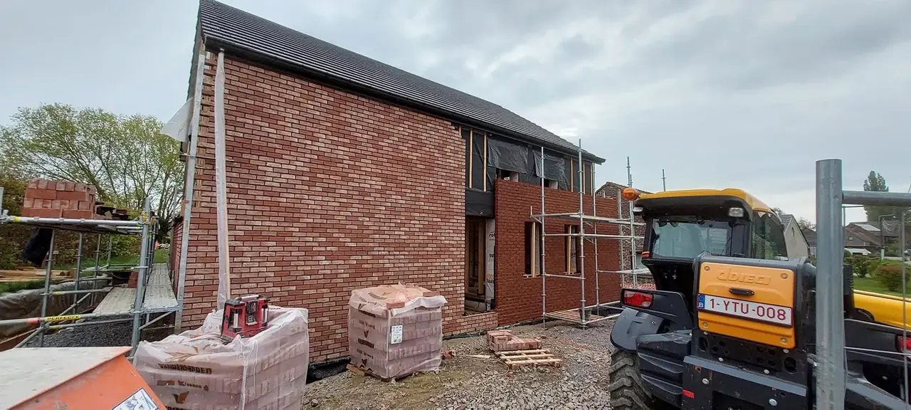 Maison en briques en construction avec chariot élévateur