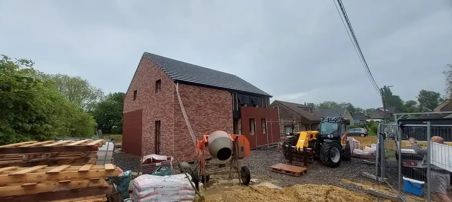 Maison en briques avec bétonnière et chariot élévateur
