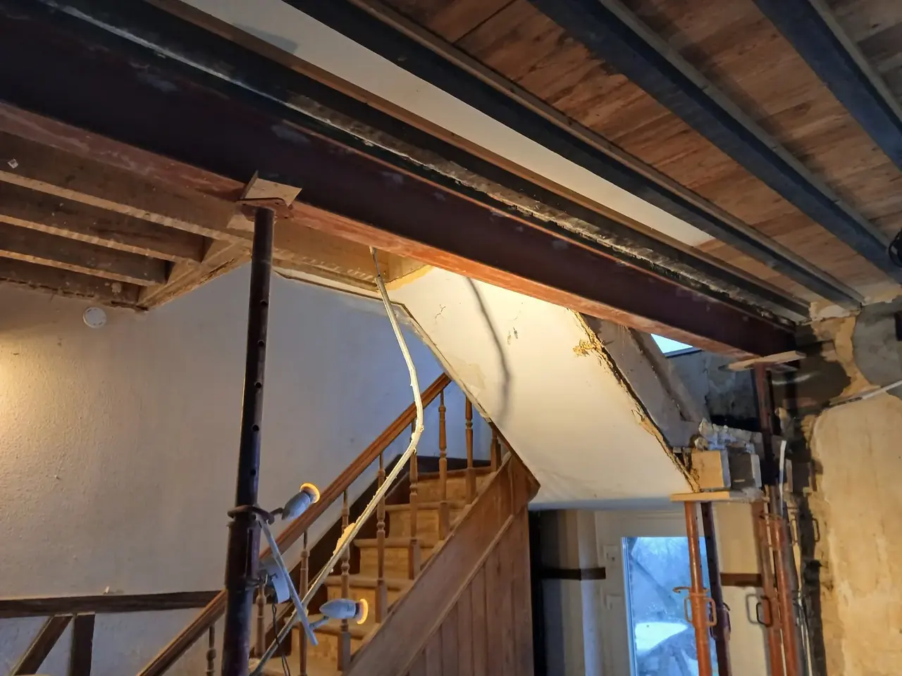Poutre métallique et solives au-dessus d'un escalier en bois