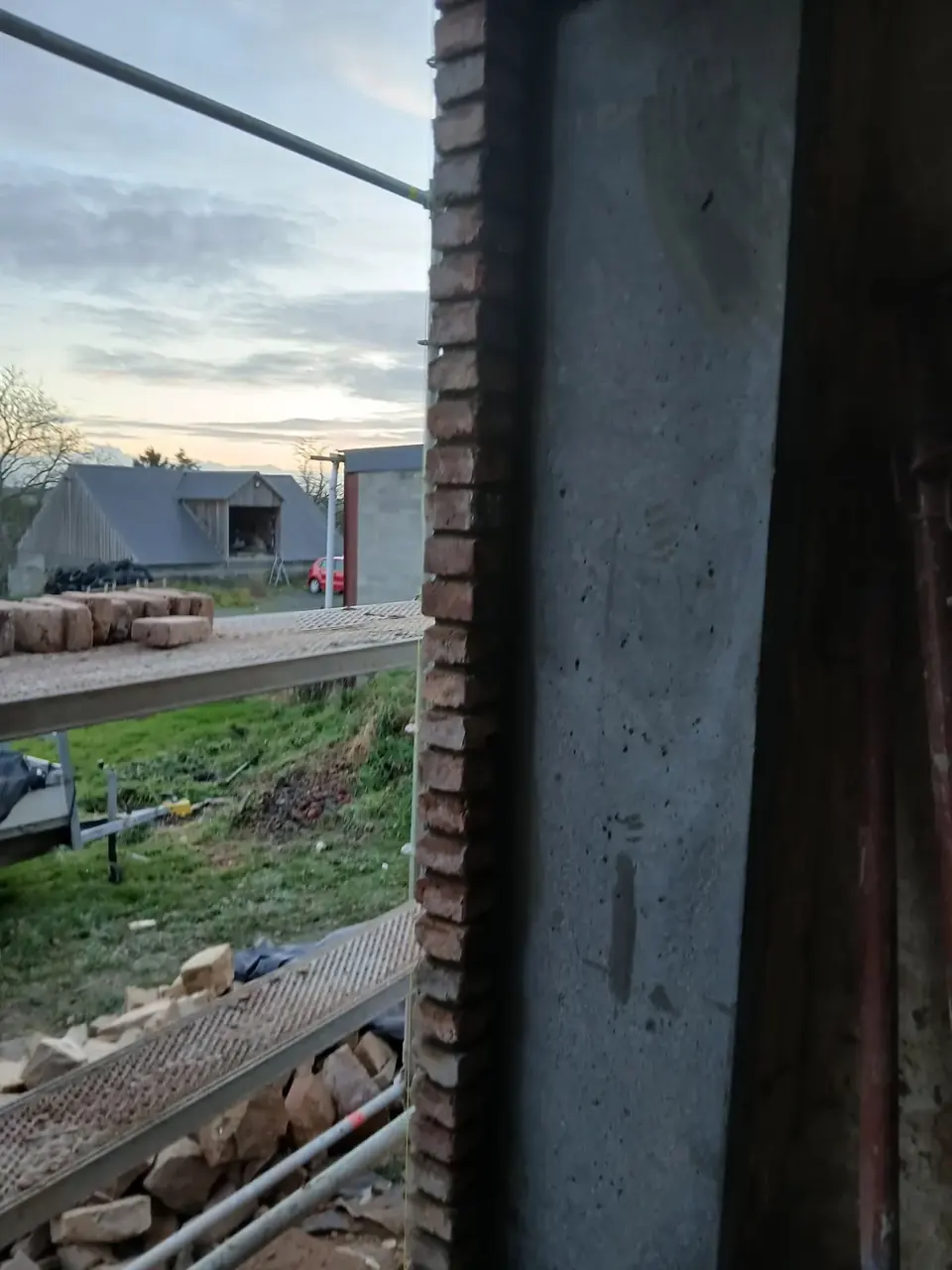 Montant de béton et briques devant un paysage de soirée