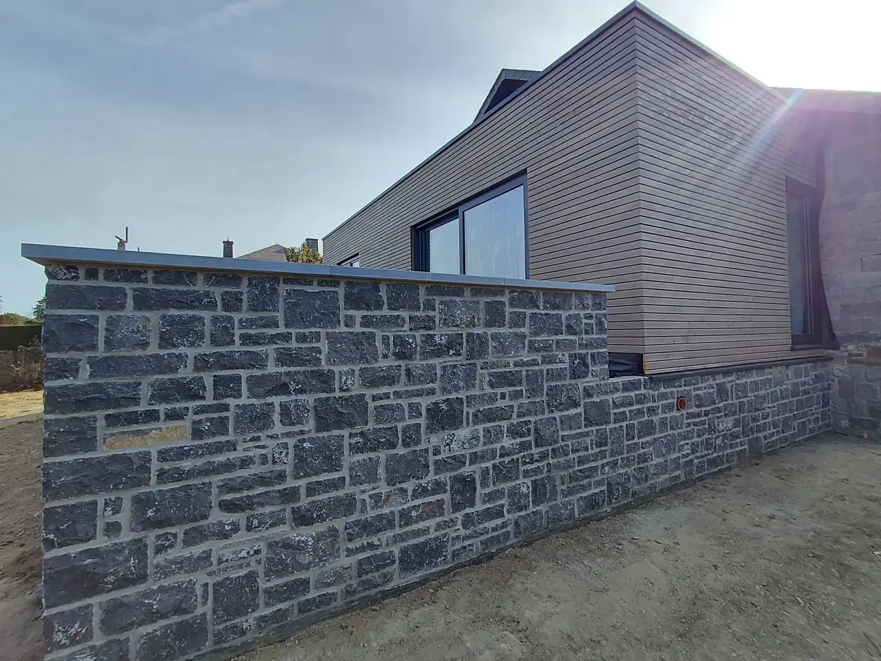 Extension en bardage bois et muret en pierre bleue