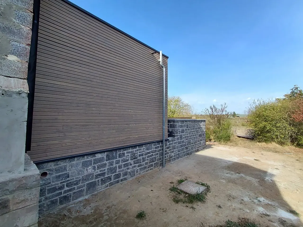 Façade en bardage bois sur muret de pierre
