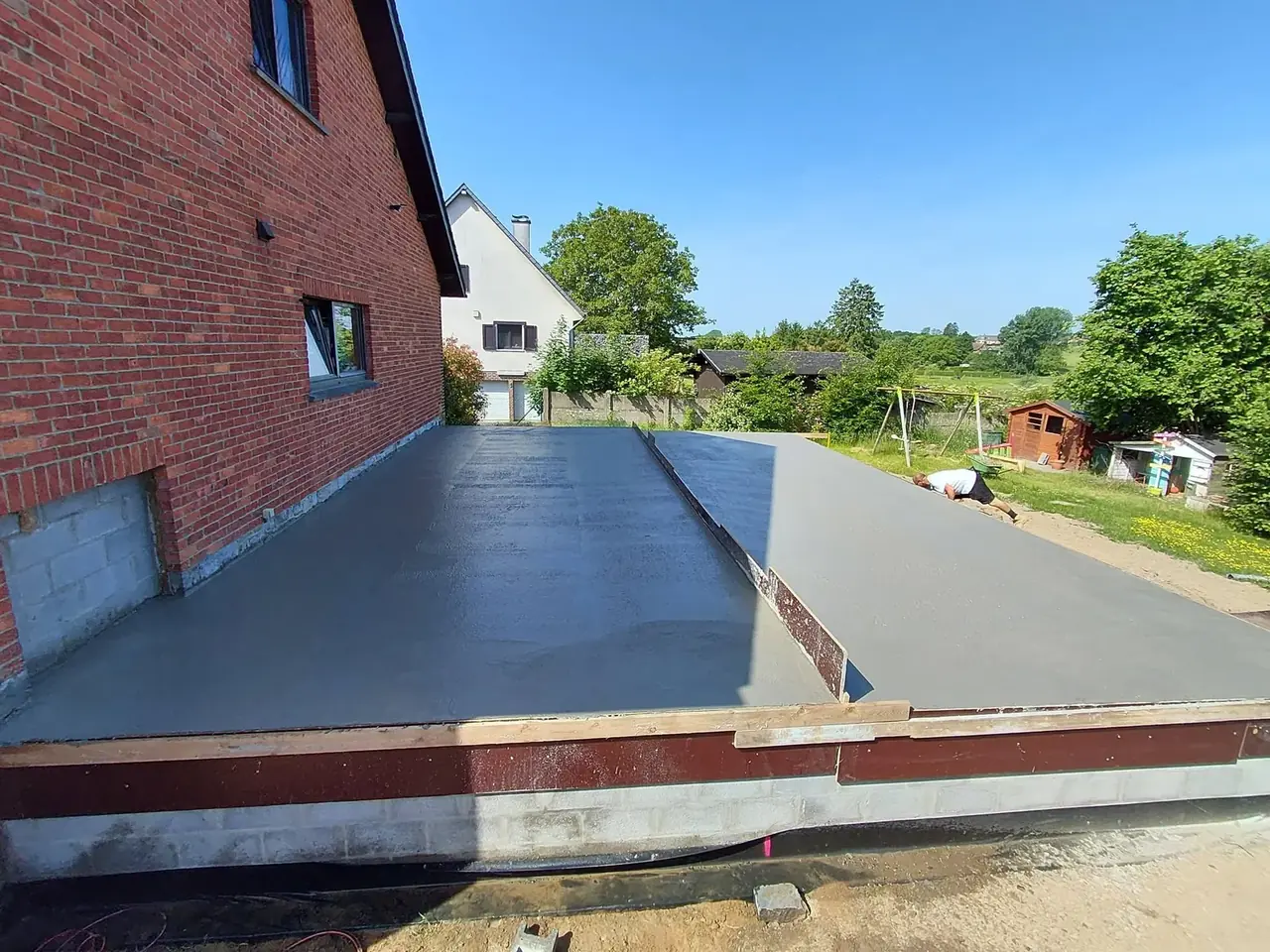 Dalle de béton le long d'une maison en briques