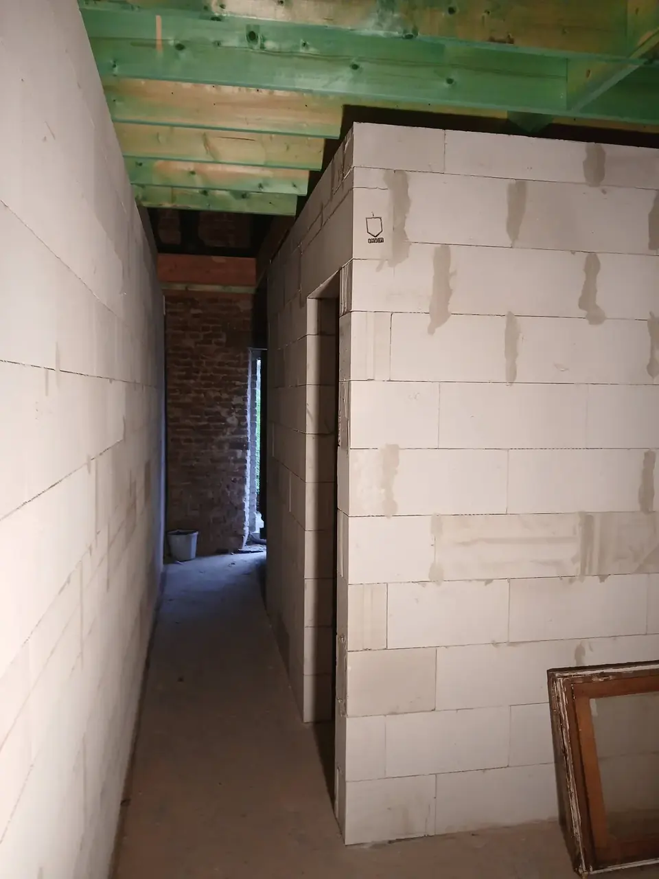 Couloir avec murs en béton cellulaire et plafond vert