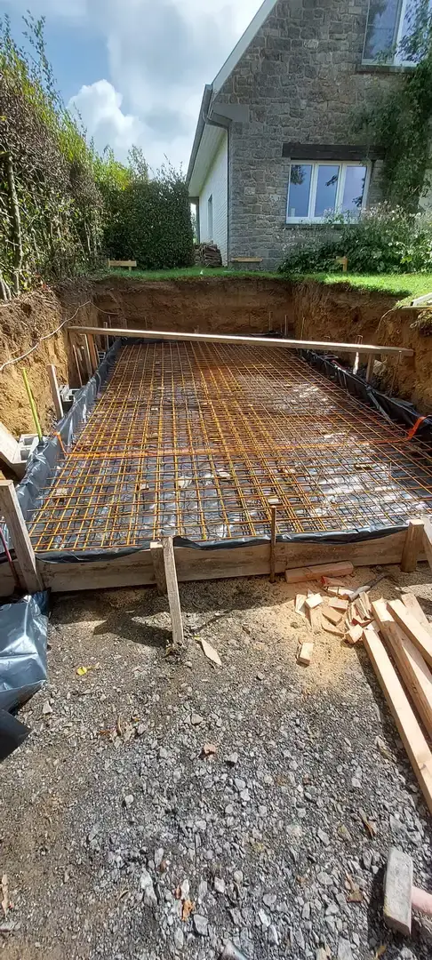 Armatures de la dalle du garage à côté d'une maison en pierre