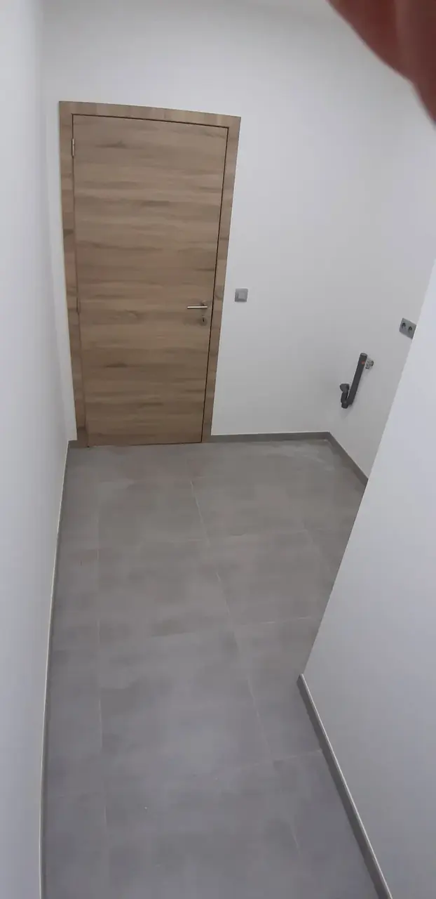 Couloir carrelé et porte en bois