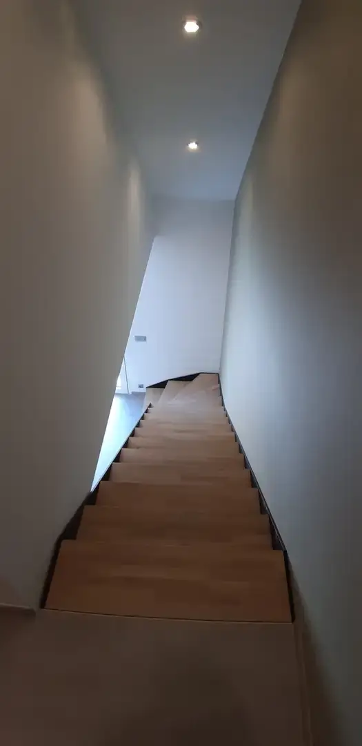 Escalier intérieur en bois dans une cage étroite