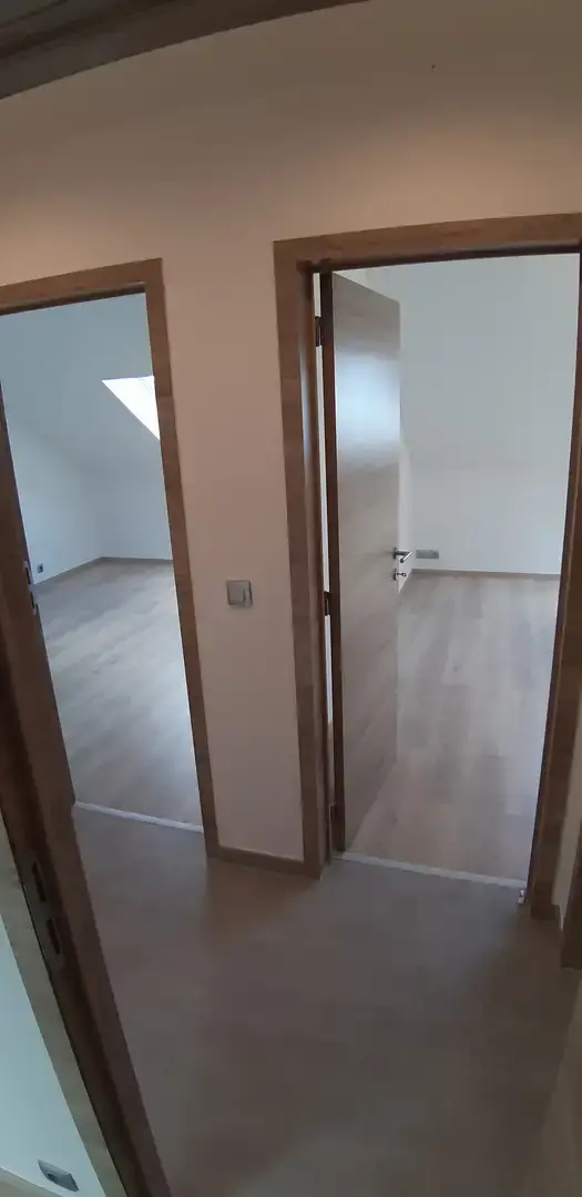 Deux portes en bois ouvertes sur une chambre lumineuse