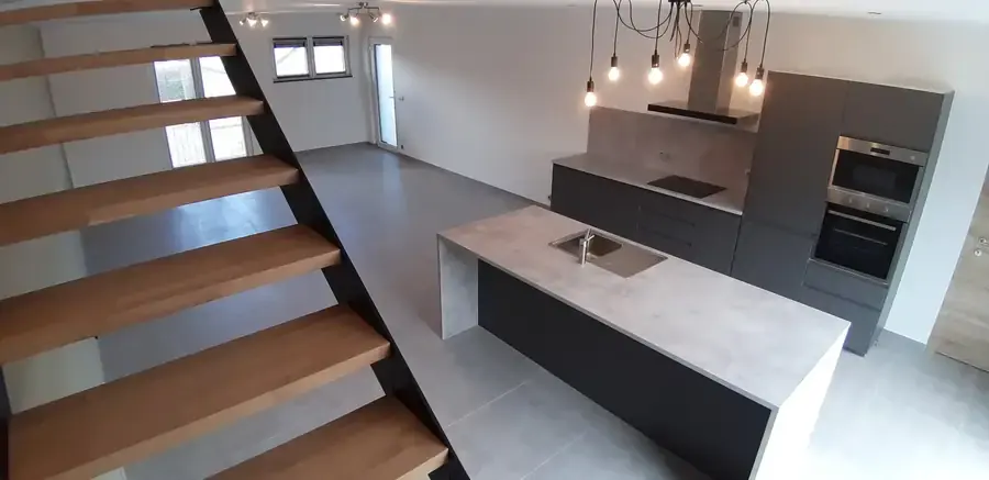 Escalier à marches de bois et cuisine avec îlot
