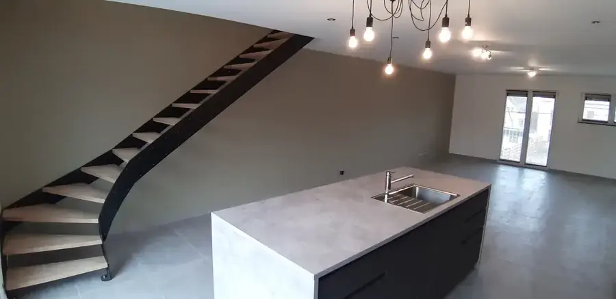 Escalier métallique à marches en bois et îlot de cuisine